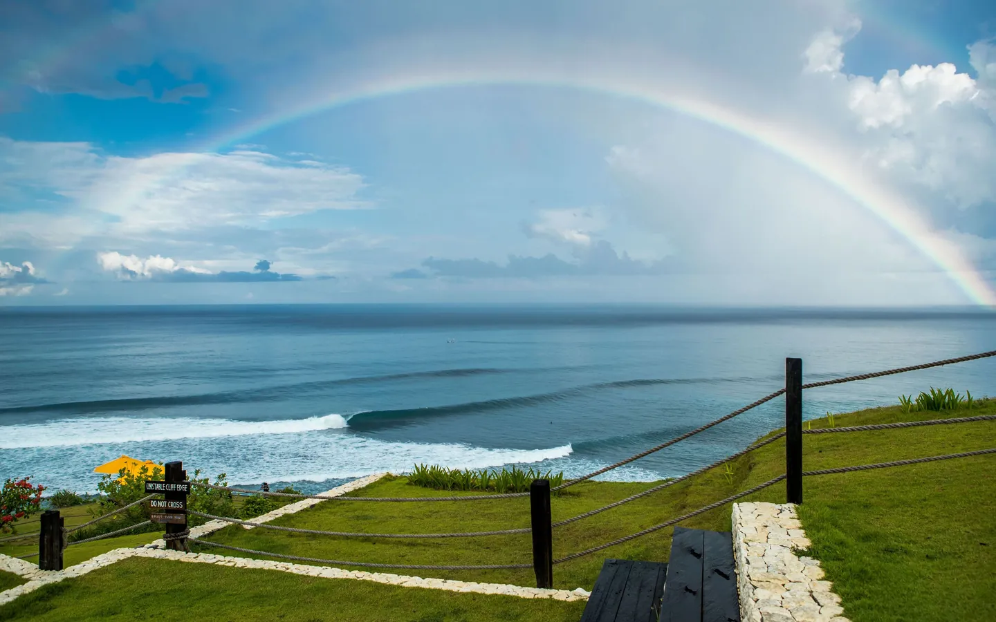 Peselancar di ombak bersih di bawah tebing Uluwatu