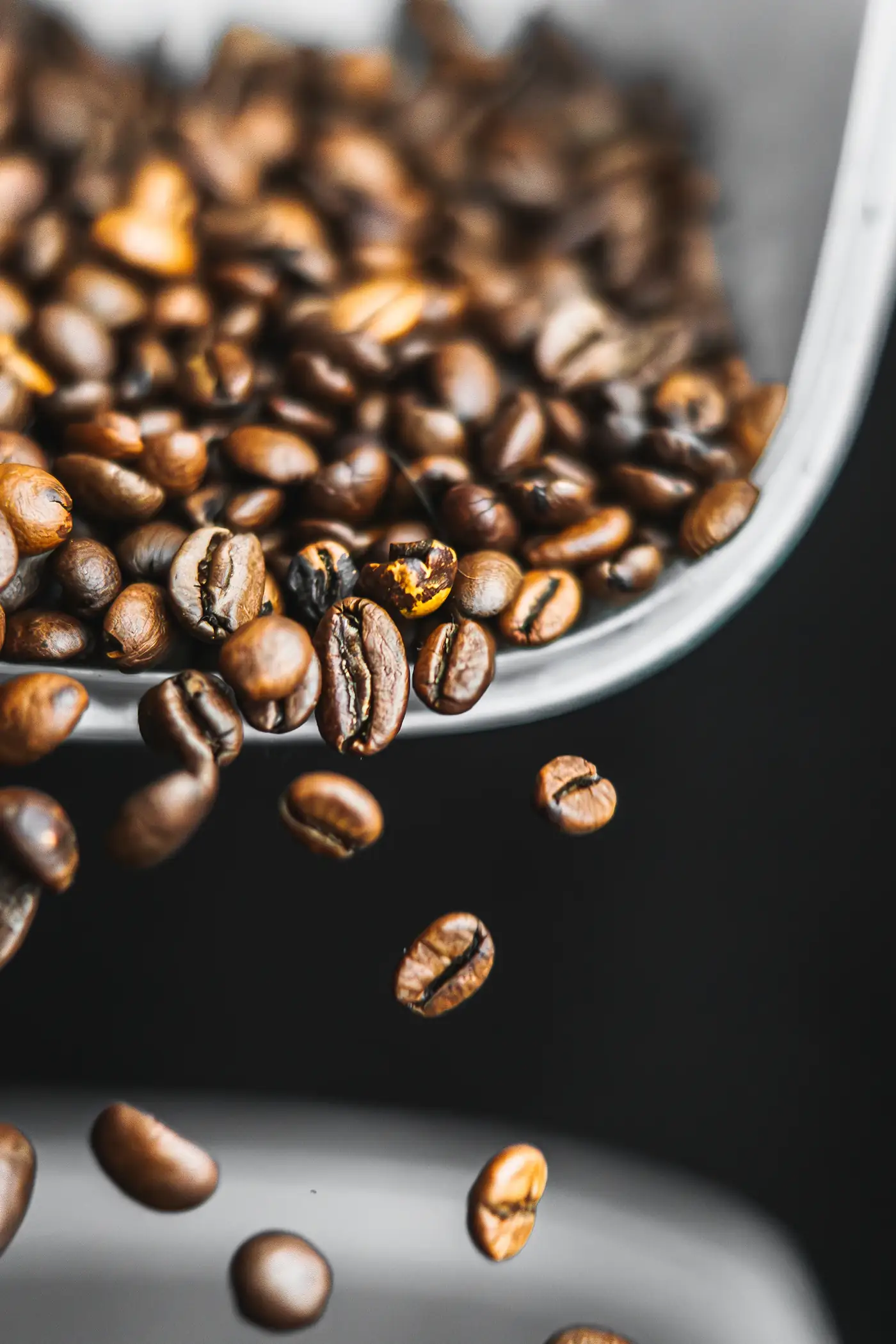 Beans spilling from a metal scoop