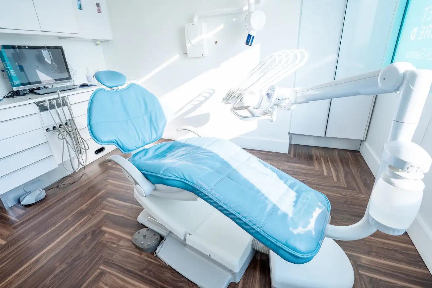Blue dental chair in sunlight on a herringbone floor