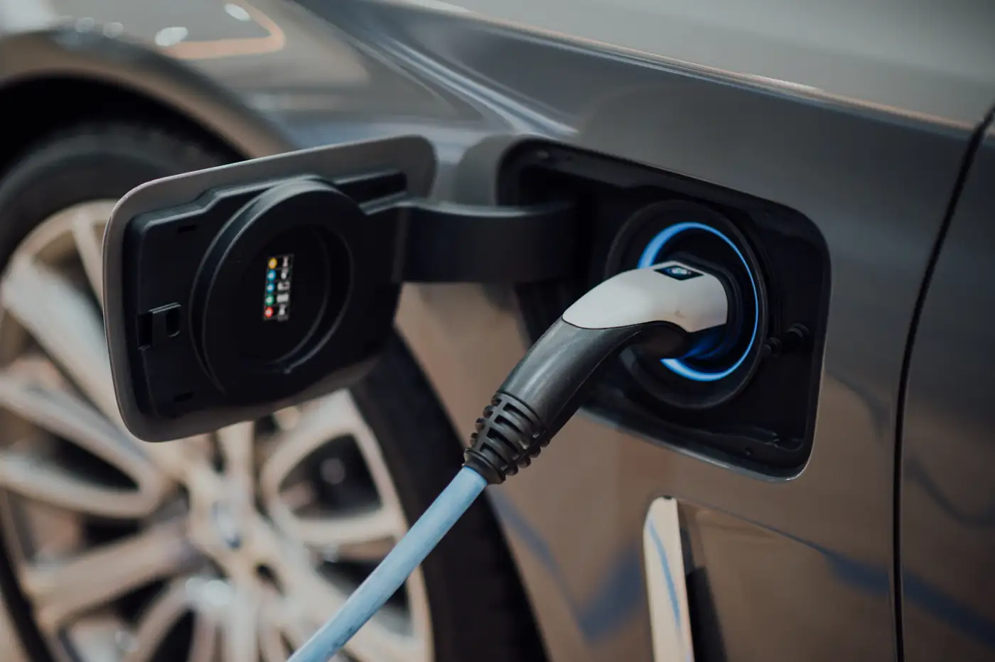 Charging plug connected to a car with a blue ring of light