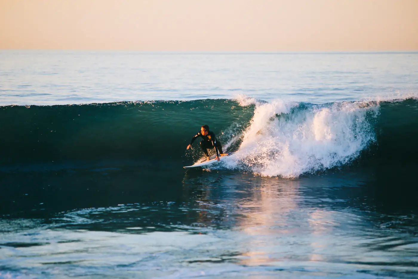 Surfer on a wave at sunset