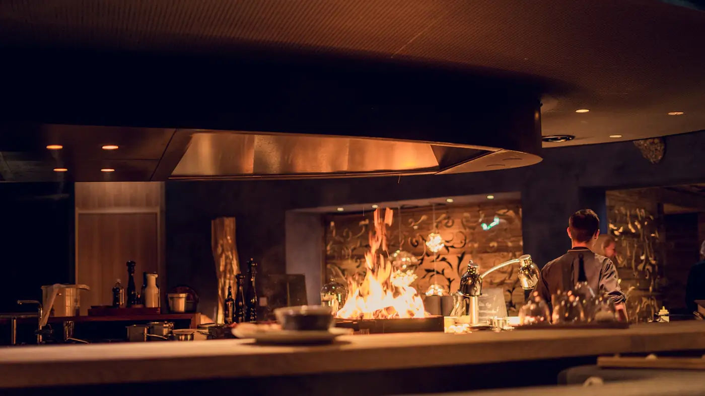 Open kitchen fire under a copper hood